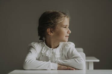 Schoolgirl contemplating at desk in classroom - SSGF00315