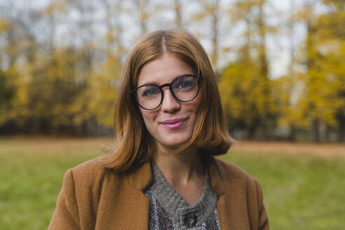 Schöne Frau mit Brille lächelnd im Park - MGIF01131