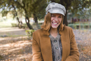 Glückliche junge Frau mit Baskenmütze im Herbstpark - MGIF01161