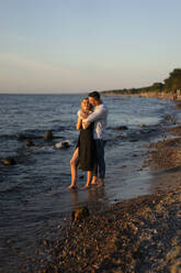 Man embracing woman at beach shore - SSGF00328