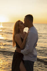 Young couple kissing each other at beach - SSGF00336