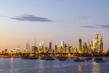 Australia, Victoria, Melbourne, Yachts floating against illuminated city skyline at dusk - FOF12300