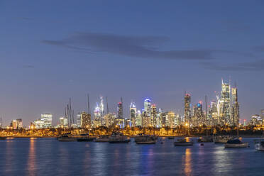 Australia, Victoria, Melbourne, Yachts floating against illuminated city skyline at dusk - FOF12302