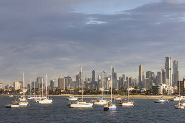 Australien, Victoria, Melbourne, Bewölkter Himmel über schwimmenden Yachten vor der Skyline der Stadt - FOF12303