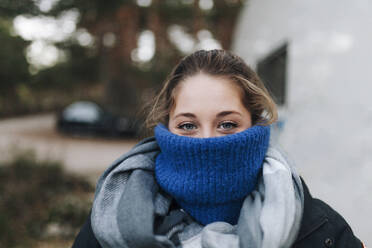 Woman's face covered with blue turtleneck sweater - MRRF01693