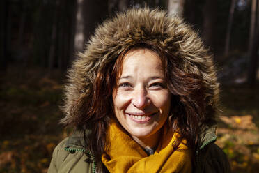 Lächelnde Frau mit Pelzmütze im Wald - MRRF01721