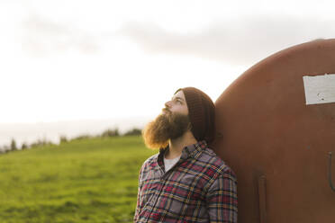 Thoughtful man leaning on storage tank - AFVF09276