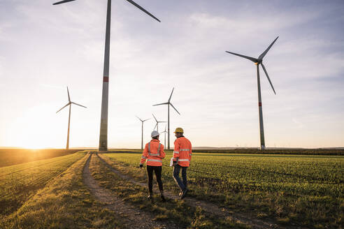 Ingenieur im Gespräch mit einem Kollegen bei Sonnenuntergang - UUF25092