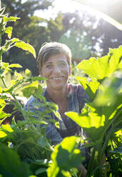 Lächelnde Frau bei der Ernte auf einem Bio-Bauernhof - BFRF02371
