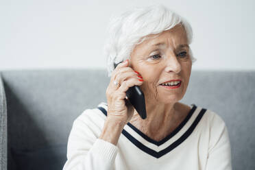 Ältere Frau telefoniert zu Hause mit ihrem Handy - JOSEF05917