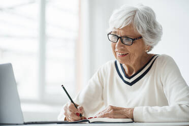 Ältere Frau nimmt an einem Videoanruf über einen Laptop zu Hause teil - JOSEF05919