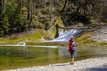 Backpacker standing at Obere Argen river, Swabia, Bavaria, Germany - LBF03550