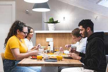 Junge Freunde beim gemeinsamen Essen zu Hause - JAQF00980