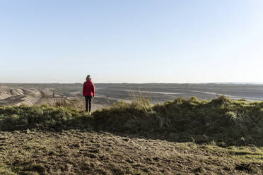 Woman looking at Garzweiler surface mine on sunny day, North Rhine-Westphalia, Germany - CHPF00810