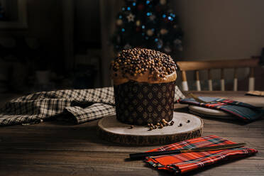 Süßer hausgemachter Panettone auf rundem Holzständer neben dem Messer für die Weihnachtsfeier - ADSF31817