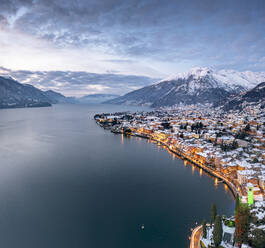 Winterlicher Sonnenaufgang über der beleuchteten Seestadt Gravedona und schneebedeckten Gipfeln, Comer See, Provinz Como, Lombardei, Italienische Seenplatte, Italien, Europa - RHPLF20843