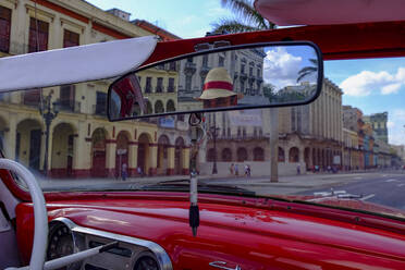Taxi driver in straw hat seen in rear-view mirror of vintage car, Havana, Cuba, West Indies, Central America - RHPLF20882