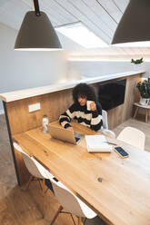 Junge Geschäftsfrau arbeitet am Laptop im Büro - JAQF00982