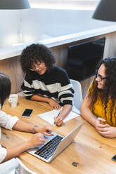 Businesswoman discussing over strategy with coworkers at office - JAQF00996