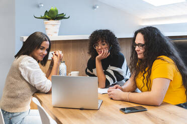Junge Geschäftsfrauen vor einem Laptop in einem Coworking-Büro - JAQF00998