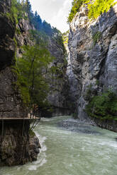 Mutter wandert mit Tochter und Sohn auf einem Wanderweg in der Aareschlucht in Meiringen, Berner Oberland, Schweiz - RUNF04724