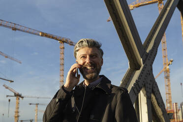 Happy businessman talking on mobile phone - IHF00632