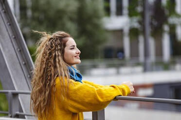 Smiling young woman with long blond hair on bridge - IHF00666