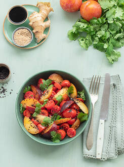 Draufsicht auf einen rohen Tomatensalat mit Obst auf einem Tisch mit grünem Tischtuch, umgeben von gesunden Zutaten - ADSF32032