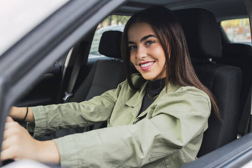 Junge lächelnde Frau fährt Auto - JRVF02103