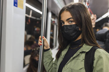 Frau mit Gesichtsschutzmaske in der U-Bahn - JRVF02122
