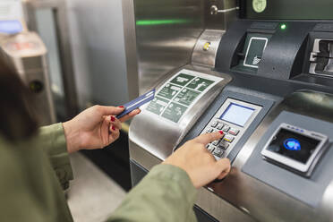 Frau beim Bezahlen mit Chipkarte in der U-Bahn - JRVF02123