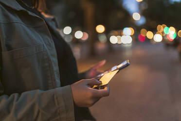 Frau mit Kreditkarte und Mobiltelefon auf der Straße - JRVF02129