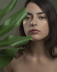 Beautiful young woman with monstera leaf - JBYF00047