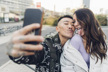 Happy couple taking selfie through smart phone - MEUF04854