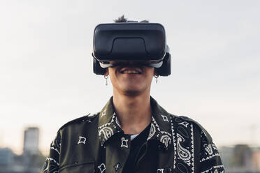 Lächelnder Mann mit Virtual-Reality-Headset in der Stadt - MEUF04881