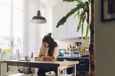 Freelancer working at desk in home office - MEUF04910