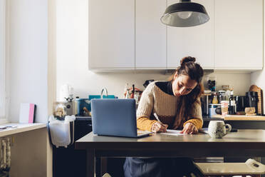 Businesswoman with laptop working at home office - MEUF04911
