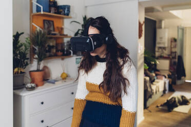 Tired woman with virtual reality headset at home - MEUF04919