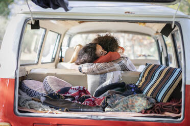 Couple embracing in campervan on road trip - EIF02425