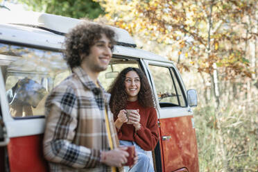 Lächelnde Freunde mit Kaffeetasse schauen weg - EIF02473