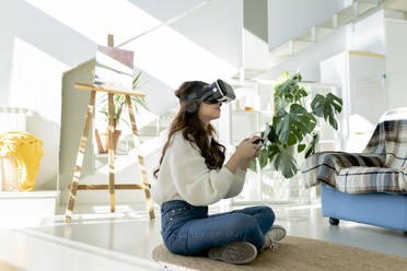 Frau mit Virtual-Reality-Headset spielt Videospiel zu Hause - JCCMF04705
