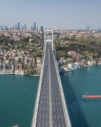 Aerial view of a container ship sailing the Marmara sea going under Patih Sultan Mehmet Koprusu bridge in Istanbul, Turkey. - AAEF13507