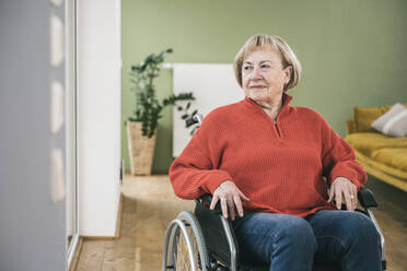 Nachdenkliche Frau mit Körperbehinderung im Rollstuhl - UUF25103