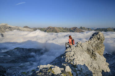 Wanderin mit Blick auf das nebelverhangene Tal in den Ortler Alpen - ANSF00122