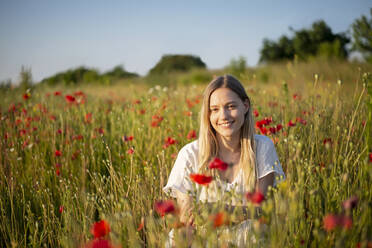 Lächelnde junge Frau im Mohnfeld - BFRF02394