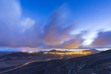 Auto Spur Lichter auf Wüste Straße überqueren das karge Land in der Abenddämmerung, Vallebron Aussichtspunkt, Fuerteventura, Kanarische Inseln, Spanien, Atlantik, Europa - RHPLF20958