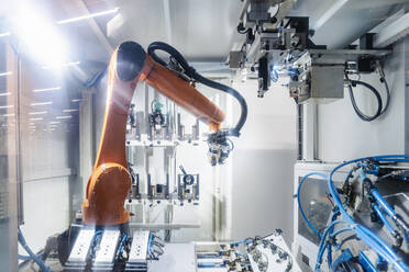 Beleuchteter Roboterarm bei der Arbeit in der automatisierten Industrie - DIGF16988