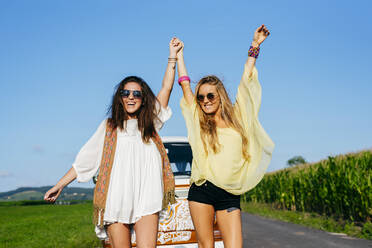 Zwei hübsche und glückliche kaukasische Mädchen in Sommerkleidung stehen auf der Straße vor einem Lieferwagen - ADSF32197