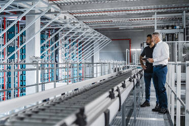 Geschäftsmann mit Lagerleiter hält Tablet-PC in der Industrie - DIGF17001