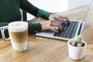 Freiberufler mit Laptop am Cafétisch - PNAF02614